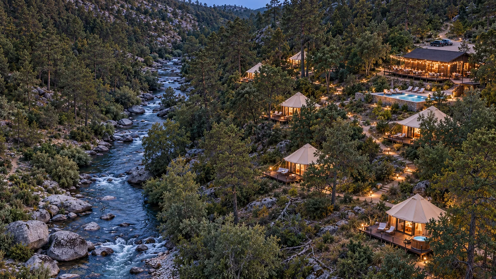 Canvas suites glowing beside a river in a forest at blue hour