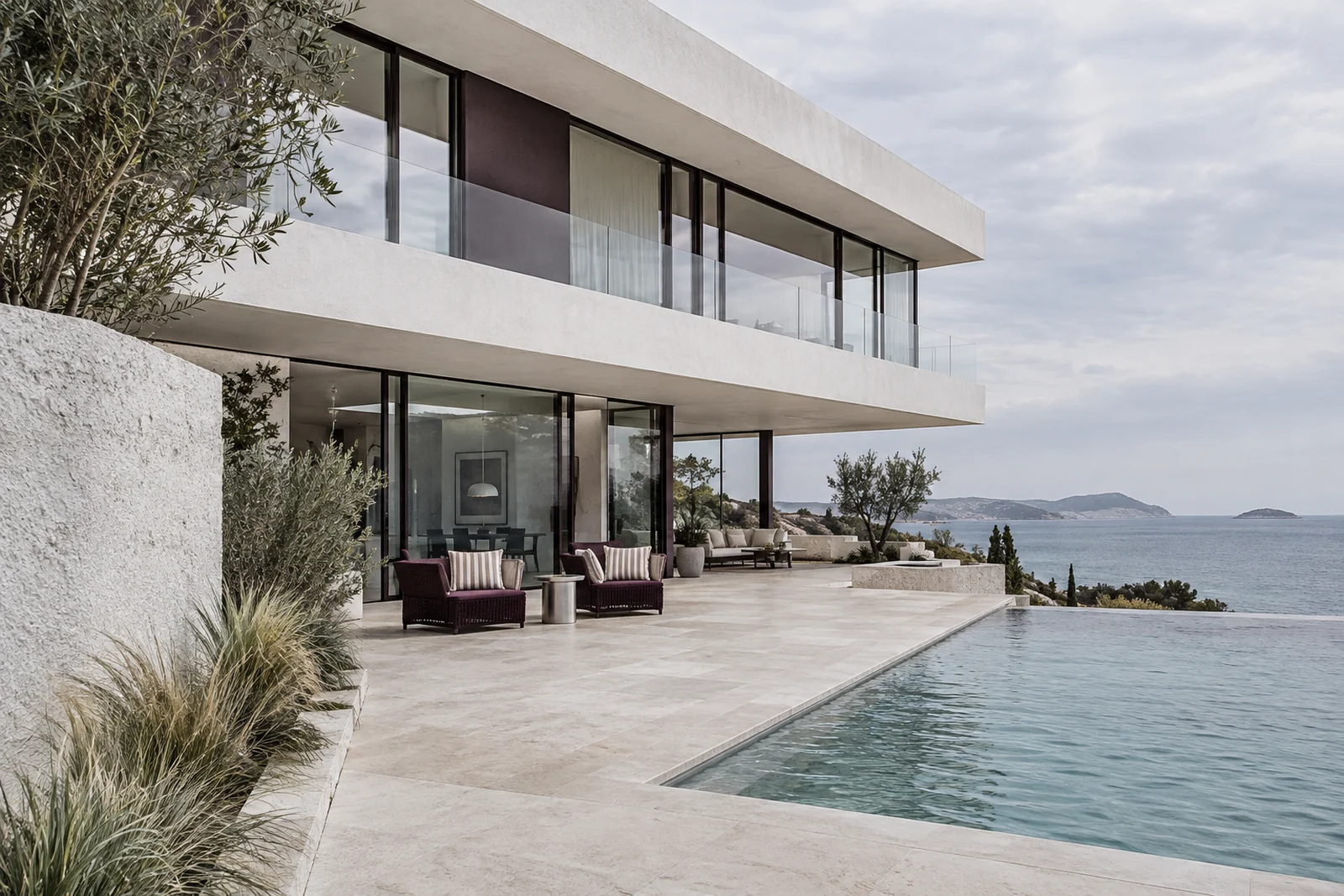 A white cantilevered coastal home with an aubergine-framed terrace and sea view